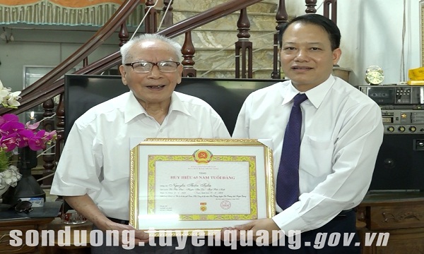 Đồng chí Giám đốc Sở Kế hoạch và Đầu tư Vân Đình Thảo trao Huy hiệu Đảng tại huyện Sơn Dương